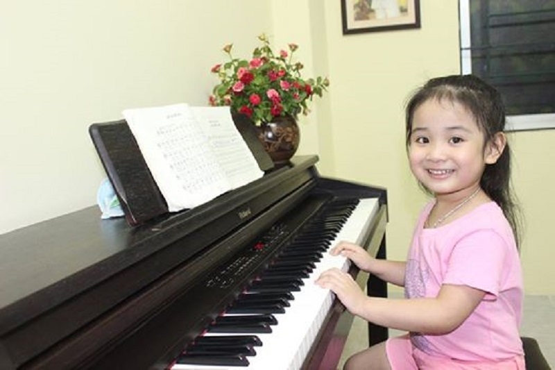 Bé học chơi đàn piano.